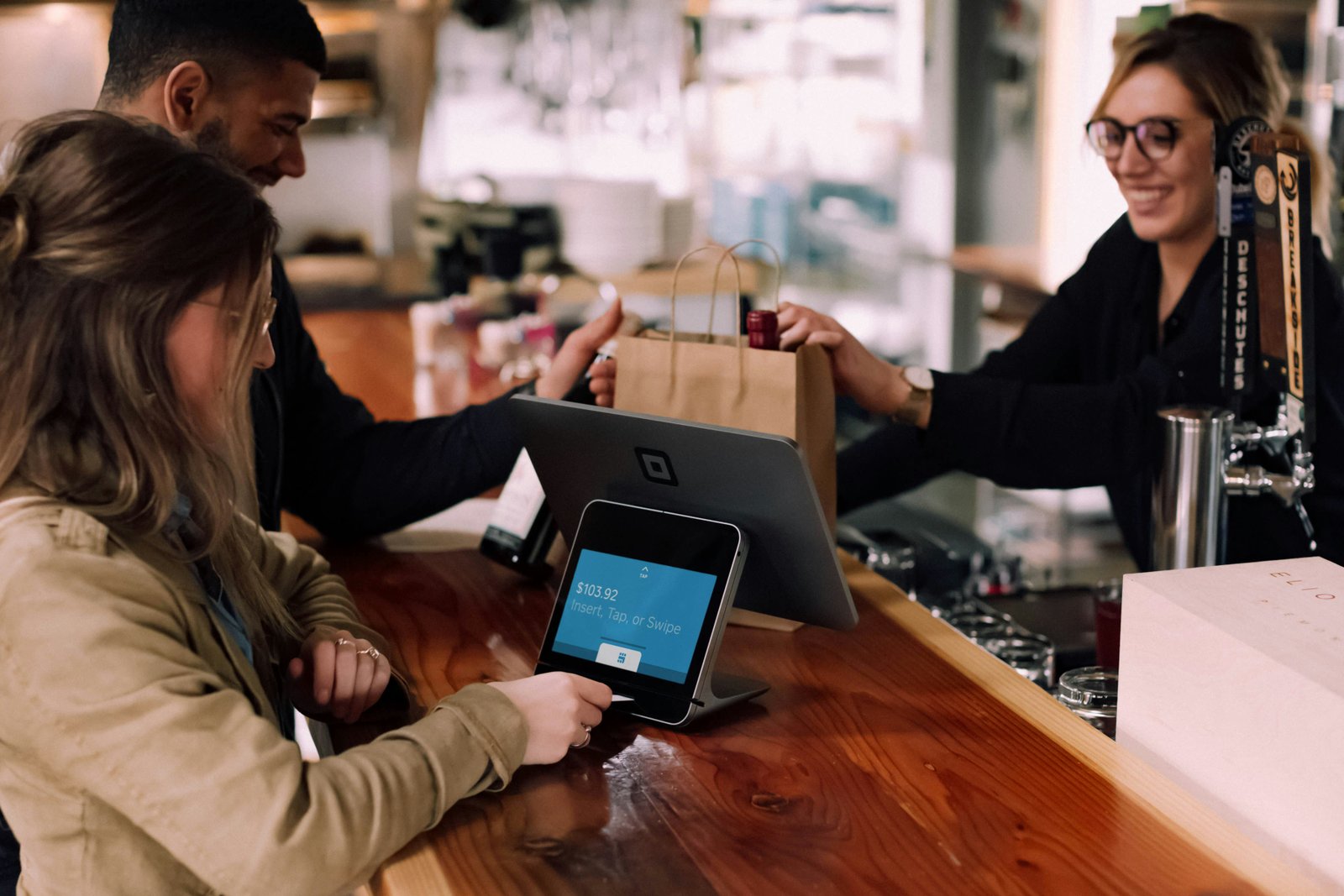 Customer paying at a shop counter with a card reader