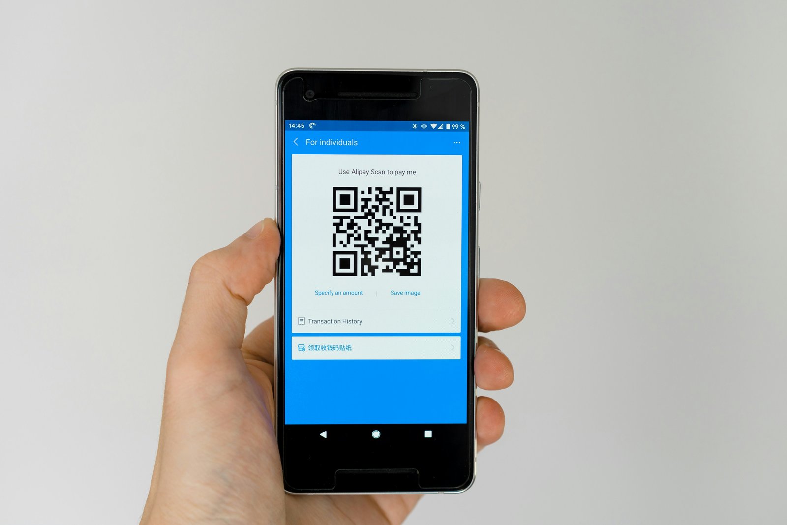Hand holding a phone scanning a QR code